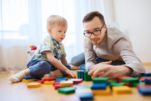 Kind spielt mir Erzieher mit Bauklötzen