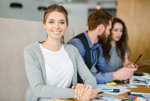 Businessfrau mit Ringbuch vor Schreibtisch